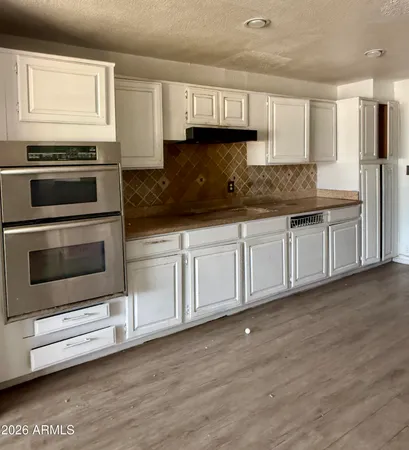 a kitchen with granite countertop white cabinets and stainless steel appliances