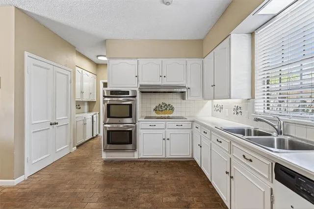 a kitchen with cabinets stainless steel appliances and a window