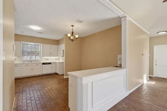 a view of a kitchen with wooden floor and electronic appliances