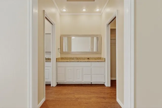 a view of a hallway with bathroom and mirror