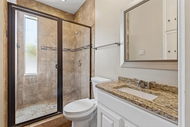 a bathroom with a granite countertop sink toilet and shower