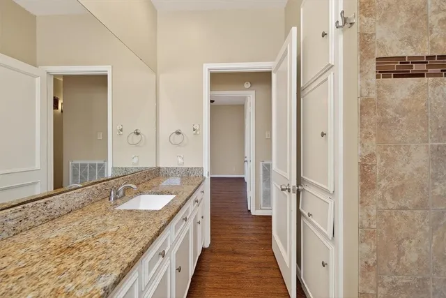 a spacious bathroom with a granite countertop tub sink and mirror