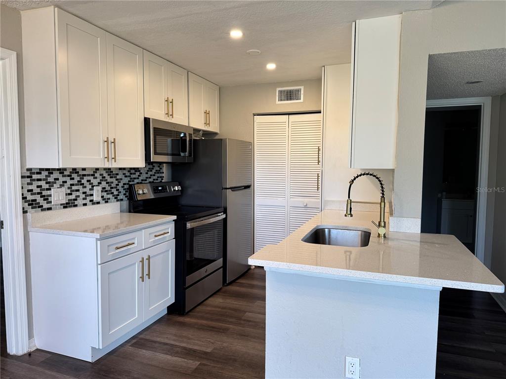 1023 South Hiawassee Road, Unit 4022 Orlando, FL 32835 - Photo 4 of 24 a kitchen with stainless steel appliances a sink a stove and cabinets