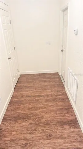 a view of an empty room with wooden floor