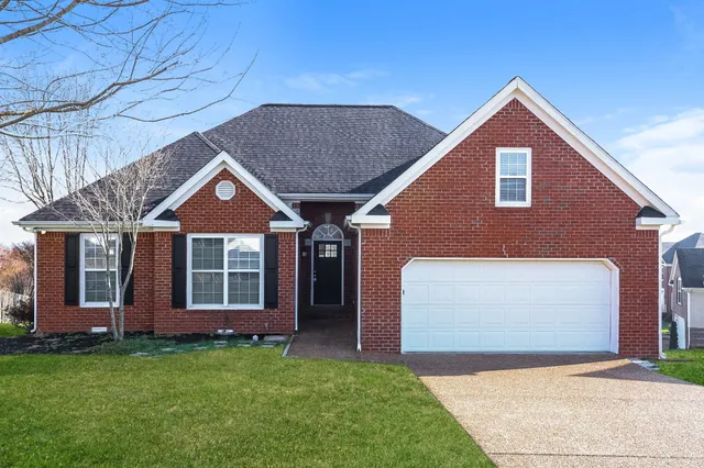 a front view of a house with a garden and yard