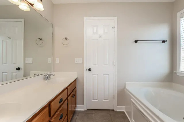 a bathroom with a tub sink and mirror
