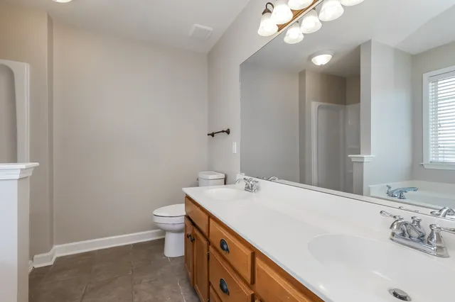 a bathroom with a sink a toilet and a mirror