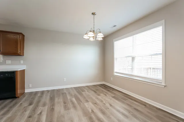 a view of a room with wooden floor and a window