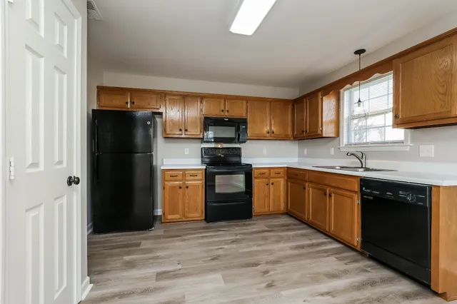 a kitchen with a refrigerator stove top oven and sink