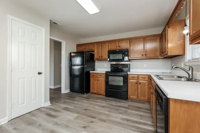 a kitchen with granite countertop a refrigerator stove top oven and sink
