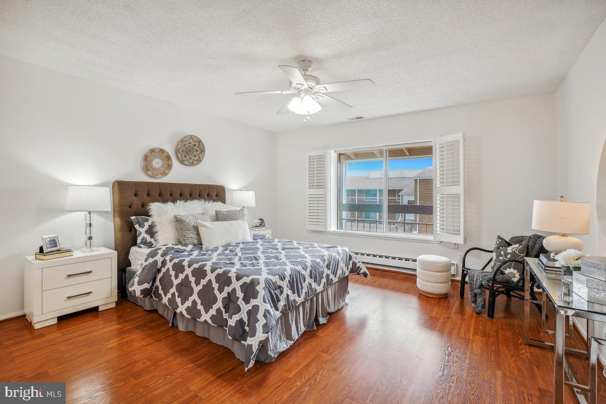 3511 Forest Edge Drive, Unit 173C Silver Spring, MD 20906 - Photo 2 of 52 a bedroom with a bed and wooden floor