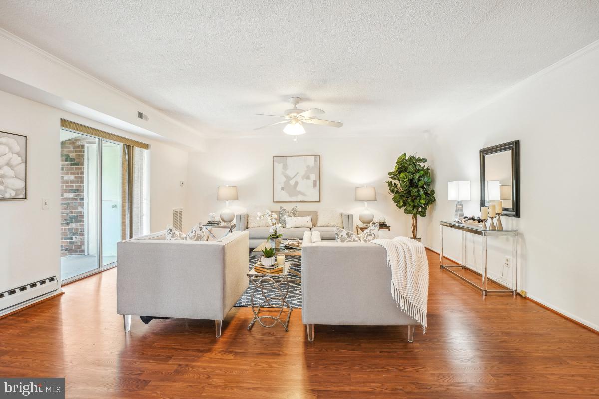 3511 Forest Edge Drive, Unit 173C Silver Spring, MD 20906 - Photo 7 of 52 a living room with fireplace furniture and a large window