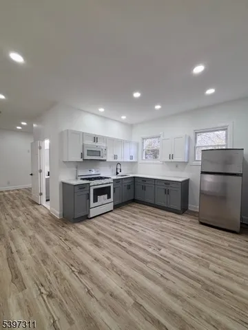 a large kitchen with stainless steel appliances granite countertop a large counter top and oven