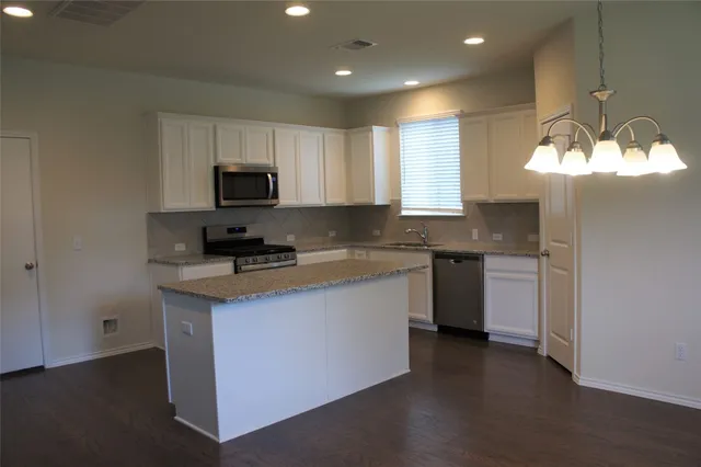 a kitchen with a sink stove and cabinets