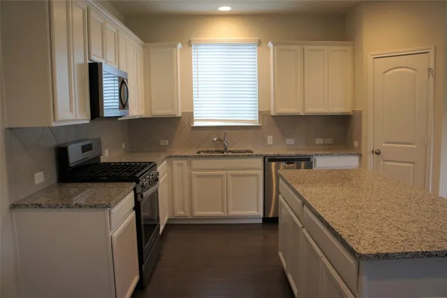 a kitchen with kitchen island a counter top space and a window