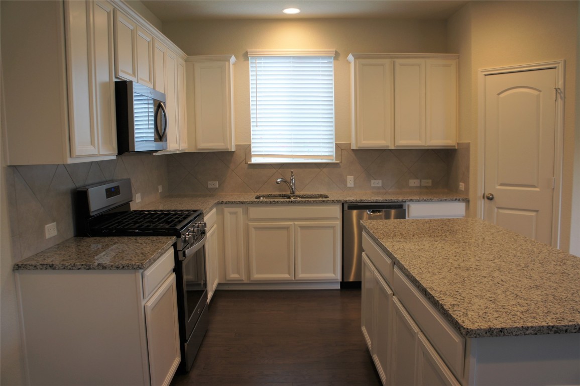 1612 Cliffbrake Way Georgetown, TX 78626 - Photo 5 of 13 a kitchen with a sink stove and cabinets