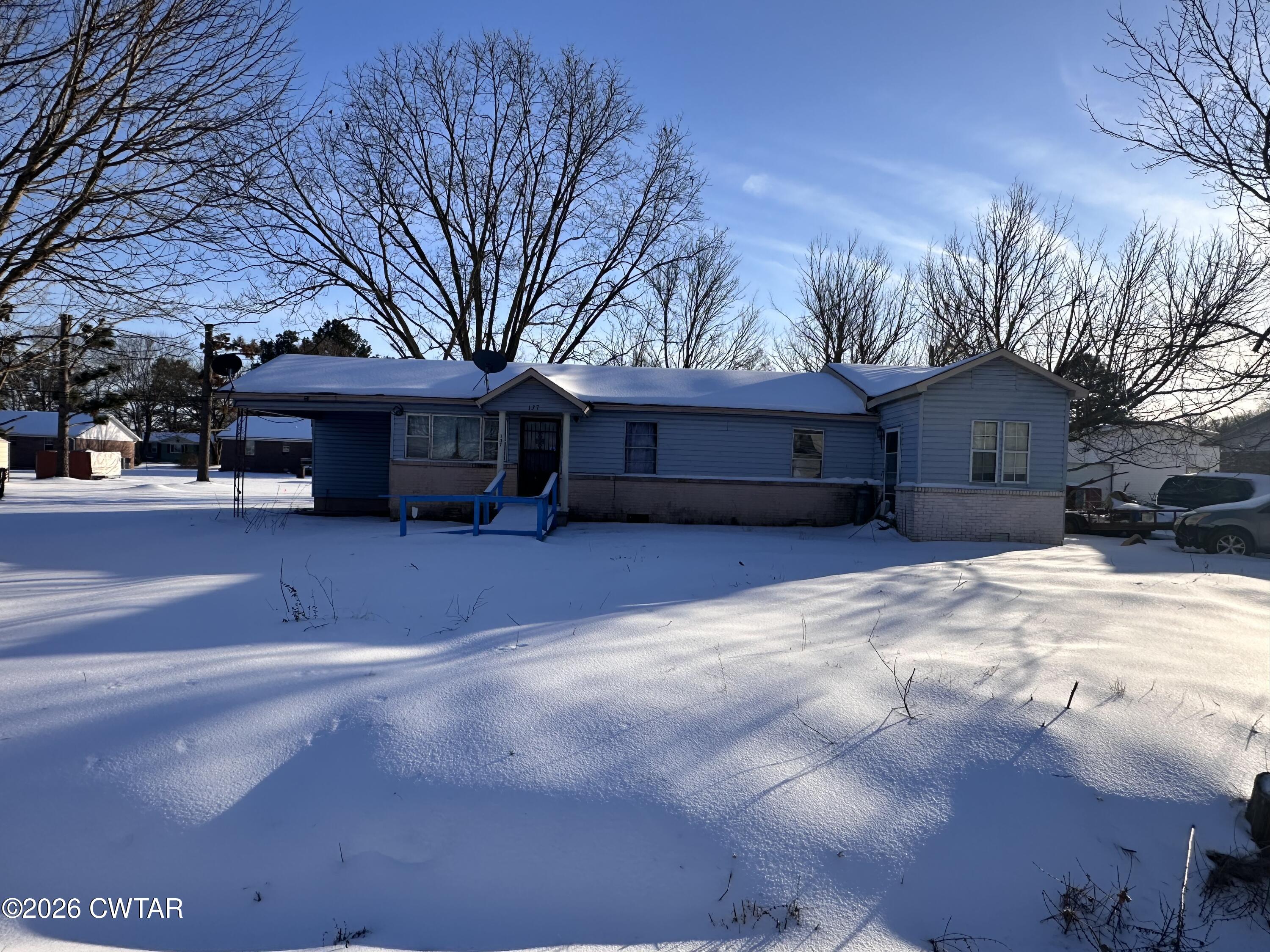 a view of a house with a yard covered with snow in front of house
