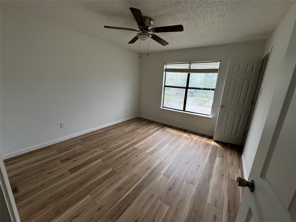 7413 Bogart Drive North Richland Hills, TX 76180 - Photo 4 of 9 wooden floor in an empty room with a window