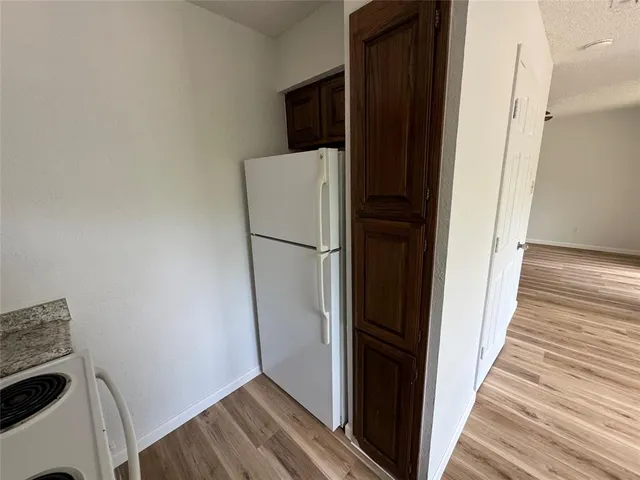 a view of a storage and utility room with wooden floor