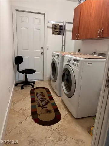 a room with a washing machine and cabinets