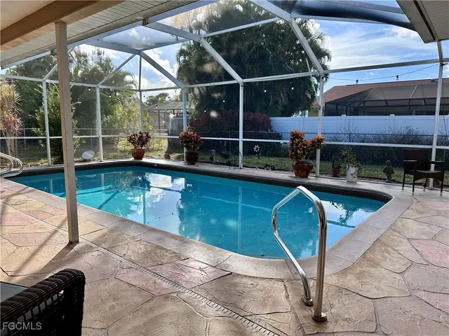 a view of a swimming pool with a patio and a yard