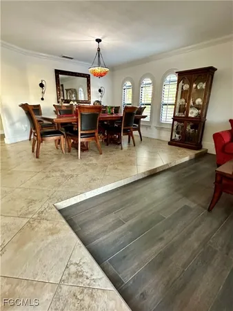 a living room with furniture dining table a chandelier and a large window