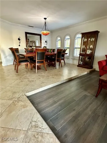 a living room with furniture dining table a chandelier and a large window