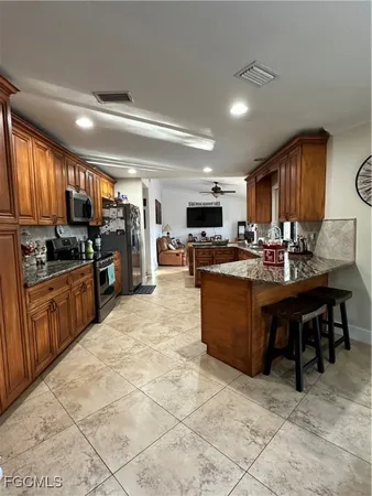 a kitchen with stainless steel appliances kitchen island granite countertop a stove sink and cabinets