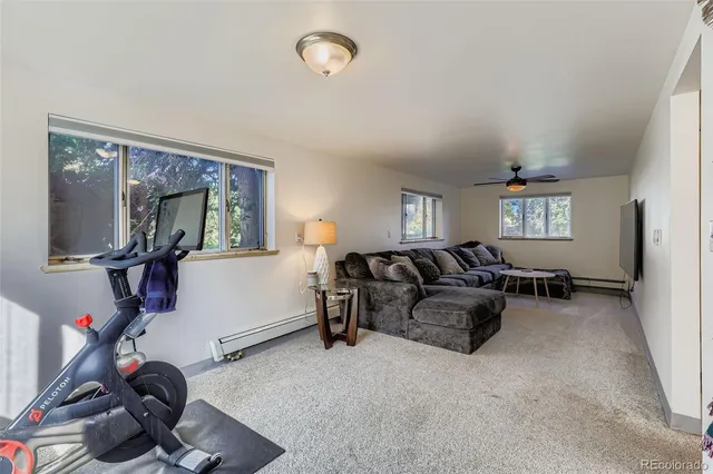 a living room with furniture a window and gym equipment