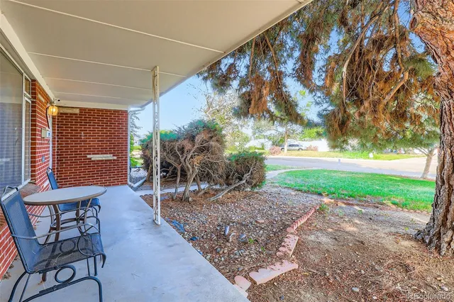 a view of a porch with furniture and a yard