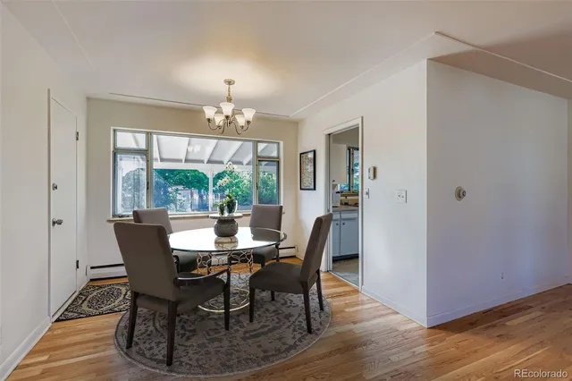 a dining room with furniture a chandelier and wooden floor