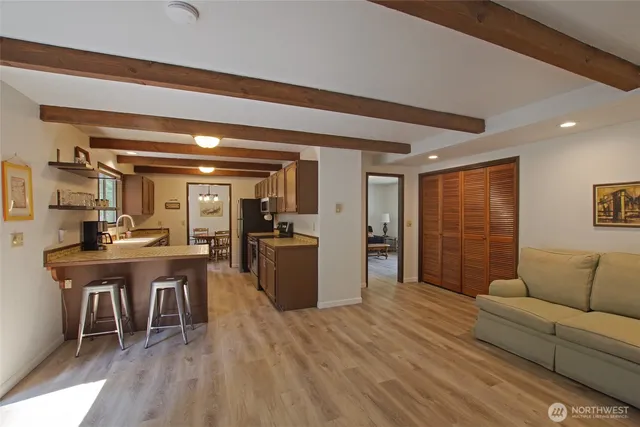 a living room with furniture a dining table and chairs with kitchen appliances