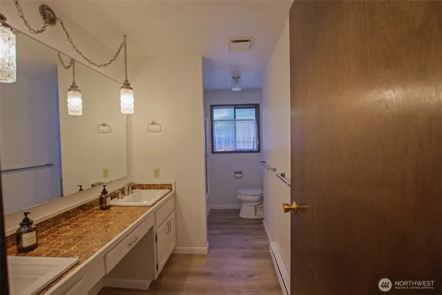 a bathroom with a granite countertop sink toilet and shower
