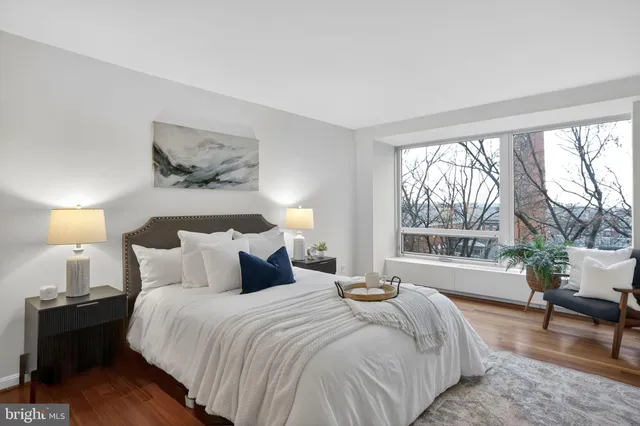 a bedroom with large bed and wooden floor