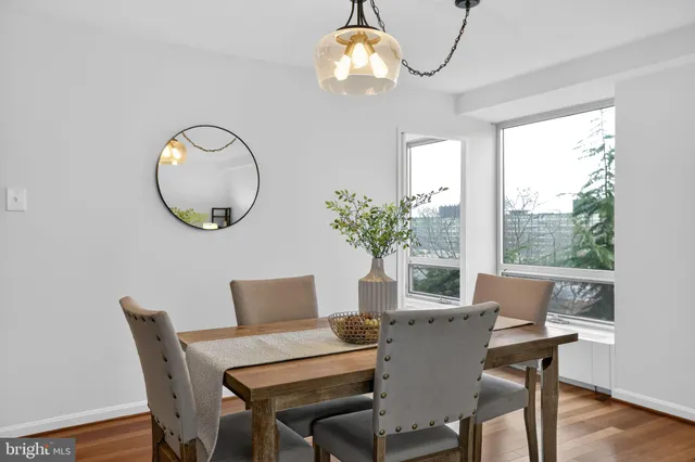 a dining room with furniture a large window and wooden floor