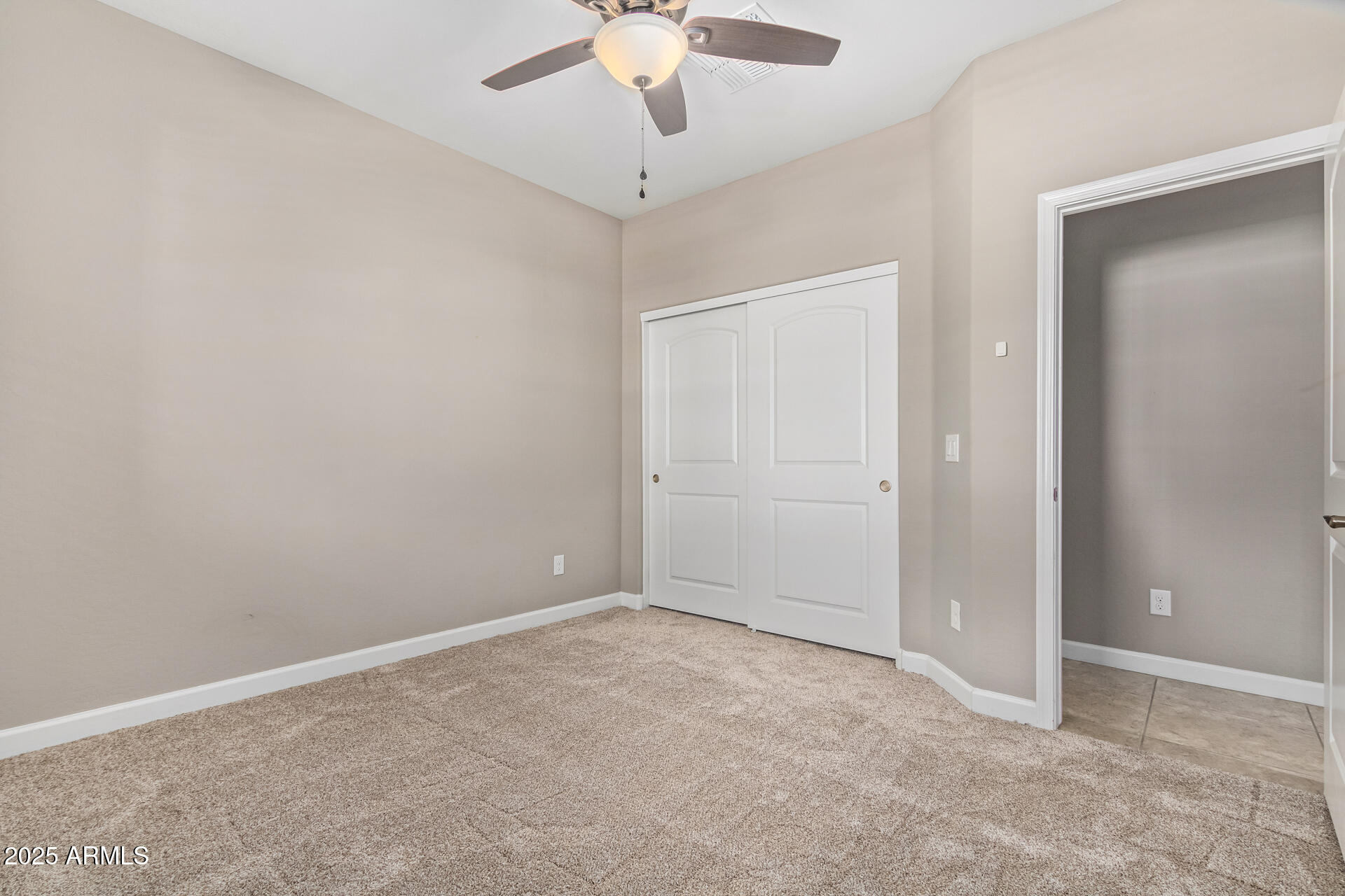 29421 West Mitchell Avenue Buckeye, AZ 85396 - Photo 24 of 40 an empty room with a ceiling fan and carpet
