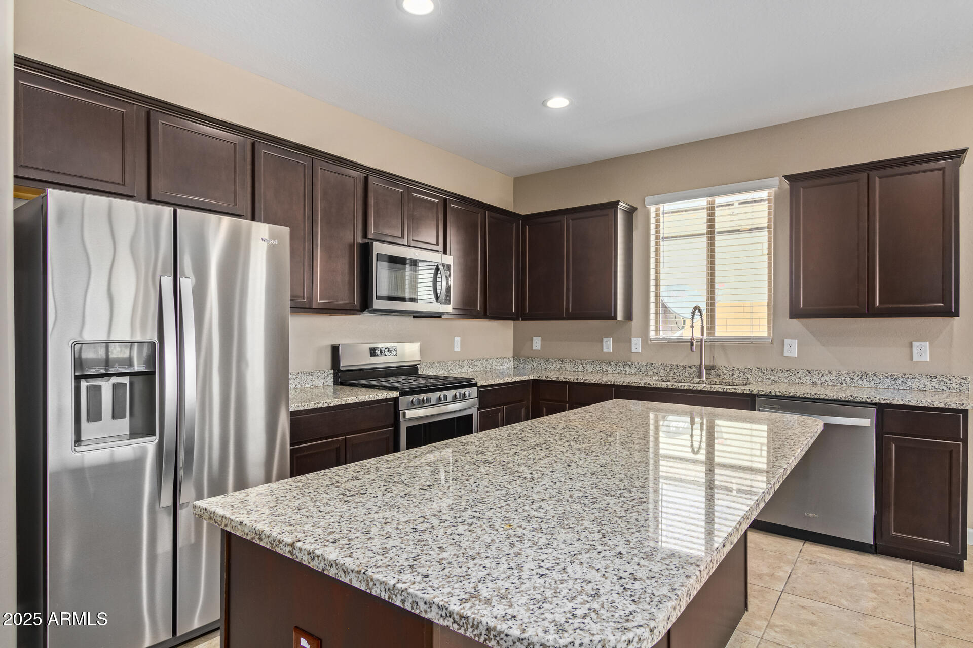 29421 West Mitchell Avenue Buckeye, AZ 85396 - Photo 7 of 40 a kitchen with stainless steel appliances granite countertop a refrigerator sink and stove