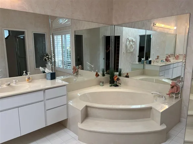 a bathroom with a tub sink and mirror