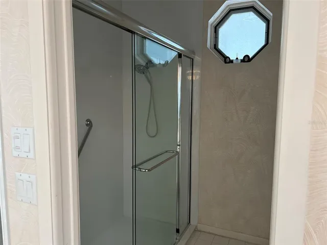 a bathroom with a glass shower door and mirror