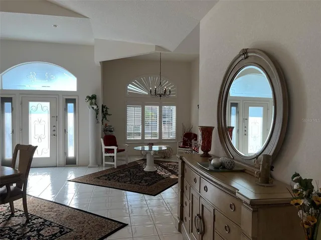 a living room with furniture a mirror a lamp and a table