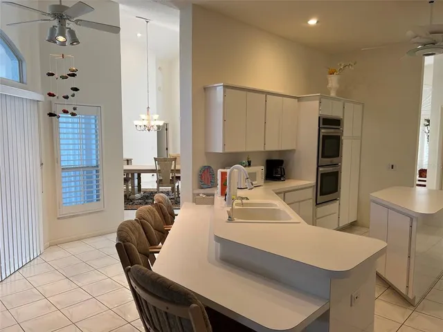 a living room with furniture a large window and kitchen view