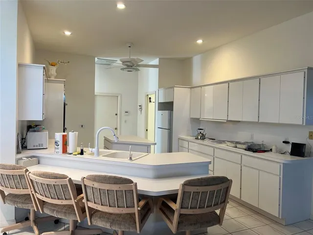a kitchen with a dining table chairs and white cabinets