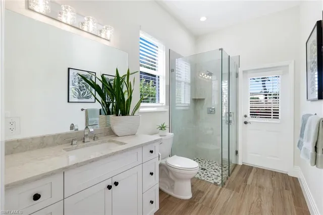 a bathroom with a granite countertop sink a toilet and shower