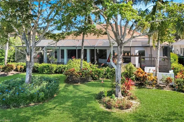 a front view of a house with a yard and a garden