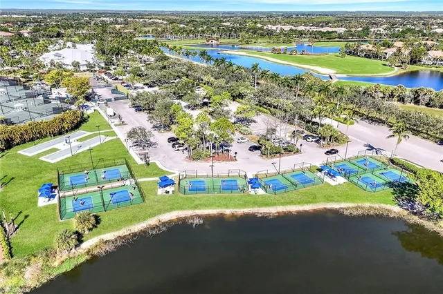 a view of a swimming pool with a lawn chairs under palm trees