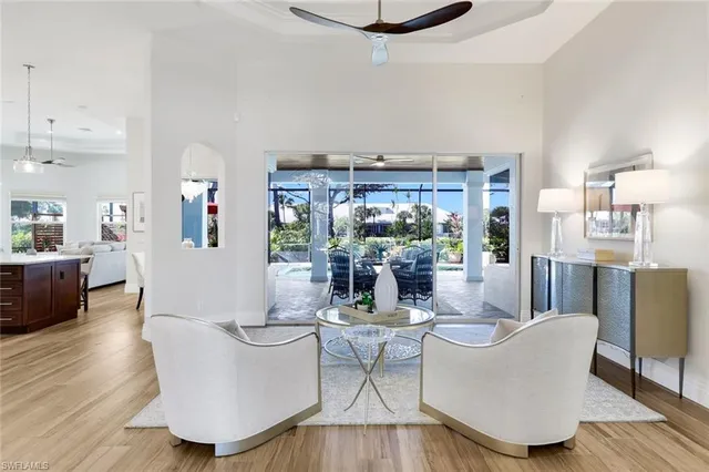 a living room with couches and kitchen view with wooden floor