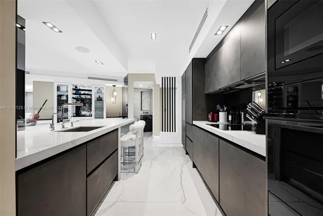 a large white kitchen with a large counter top appliances and cabinets