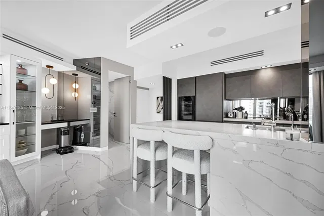 a kitchen with stainless steel appliances kitchen island granite countertop a refrigerator and cabinets