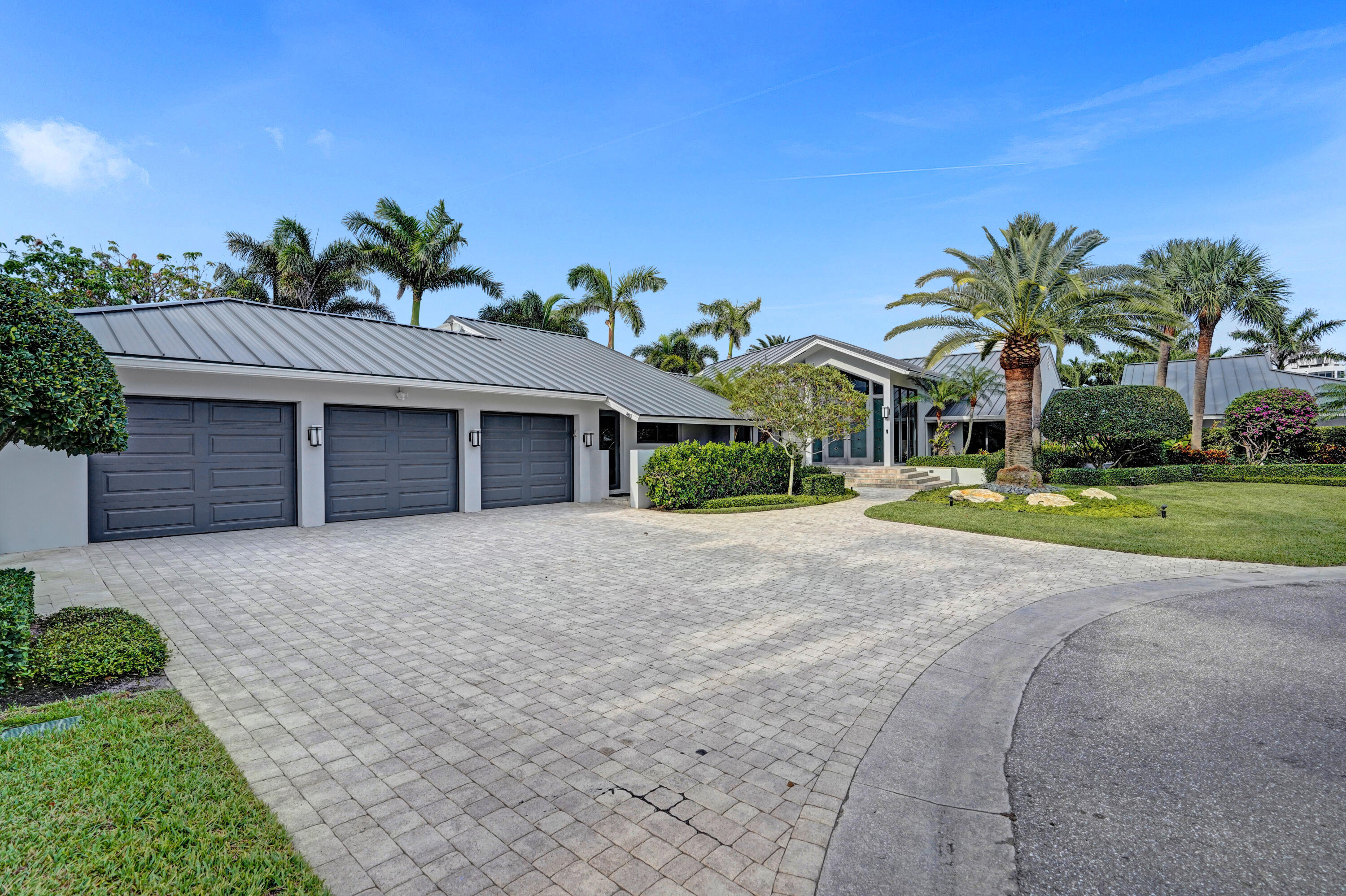 961 Iris Drive Delray Beach, FL 33483 - Photo 2 of 59 a front view of a house with a yard and garage