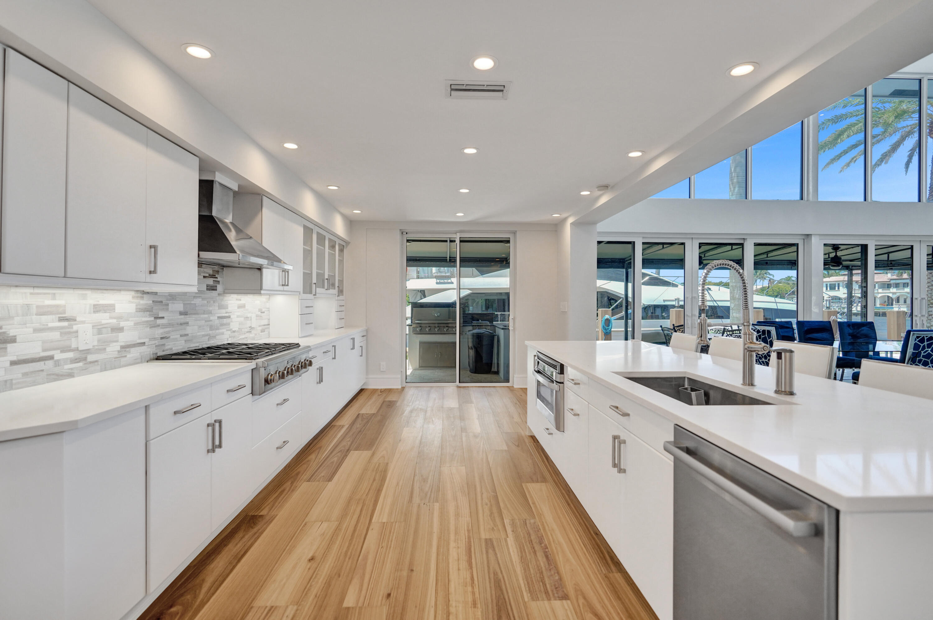 961 Iris Drive Delray Beach, FL 33483 - Photo 24 of 59 a large kitchen with stainless steel appliances granite countertop a lot of counter space and wooden floors